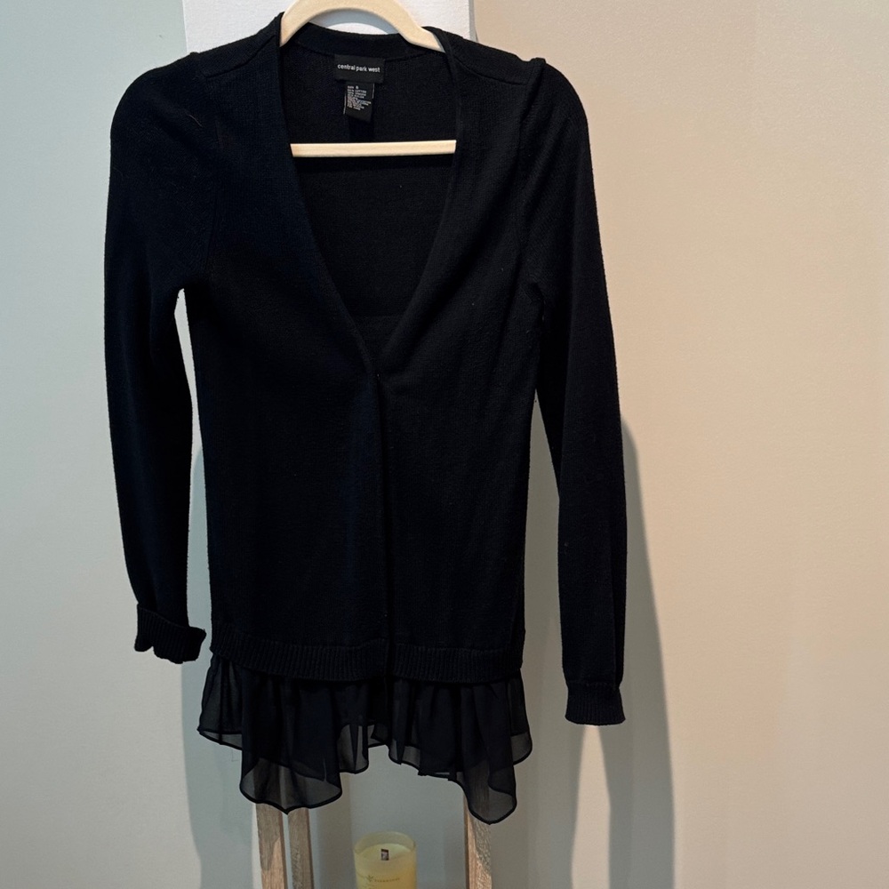 Central Park West Black Knit Cardigan with sheer ruffle at bottom. Snap closure